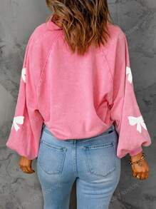 Sweatshirt à manches tombantes avec demi-boutons, nœud papillon et séquins