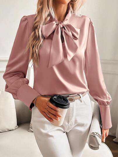 Blusa de satén rosa con cuello de lazo y mangas abullonadas - Elegante, blusa de seda adecuada para la oficina y ocasiones formales, que muestra un estilo de moda