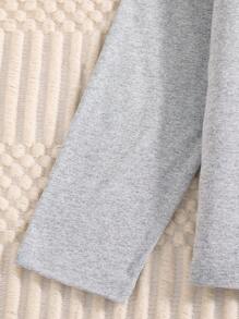 Een tweedelige set modieuze en casual lente- en herfstpyjama's voor meisjes. De set bestaat uit een schattig grijs topje met lange mouwen en een hartvormige lettersterprint en een meisjesbroek vol stervormige hartjes. De stof is multifunctioneel en comfortabel, geschikt om casual thuis te dragen of als welterustencadeautje voor je dochters.