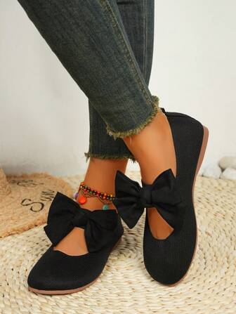 1双红色针织蝴蝶结套脚鞋，采用透气红色针织面料，鞋头饰有同色蝴蝶结。