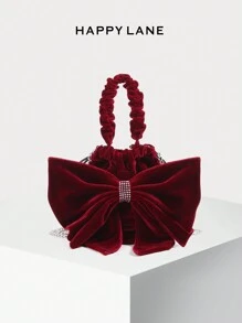 HAPPY LANE Feita de veludo vermelho encantador com um toque suave, esta bolsa apresenta um laço grande e glamoroso adornado com strass brilhantes, misturando luxo e elegância divertida. Ela vem com uma alça franzida e alça de ombro de corrente de metal, oferecendo versatilidade para estilos de transporte à mão ou a tiracolo. Perfeita para eventos noturnos, festas ou ocasiões especiais, esta peça adiciona um charme refinado e gracioso ao seu conjunto