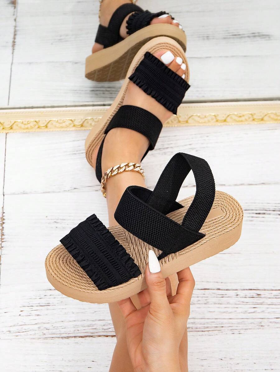 KATE MIUCH融合了法式和美式设计理念，浪漫、时尚、简约、经典、复古，适合户外、海滩和日常穿着。黑色荷叶边坡跟凉鞋，充满假日气息，优雅甜美，舒适轻便，露趾透气，黑色荷叶边圆头平底凉鞋，适合女学生穿着。