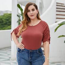 Top elástico con mangas abullonadas y detalle de lazo