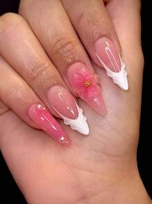 Una caja de 24 uñas de tacón stiletto medianas, con un elegante degradado de color rosa con acentos de pétalos blancos, que irradian un ambiente suave y refinado. Este set de uñas postizas incluye una lima de uñas y pegamento de gel, perfectas para todas las mujeres, ideales para uso diario, fiestas y ocasiones especiales, agregando un toque de delicado a tus dedos.