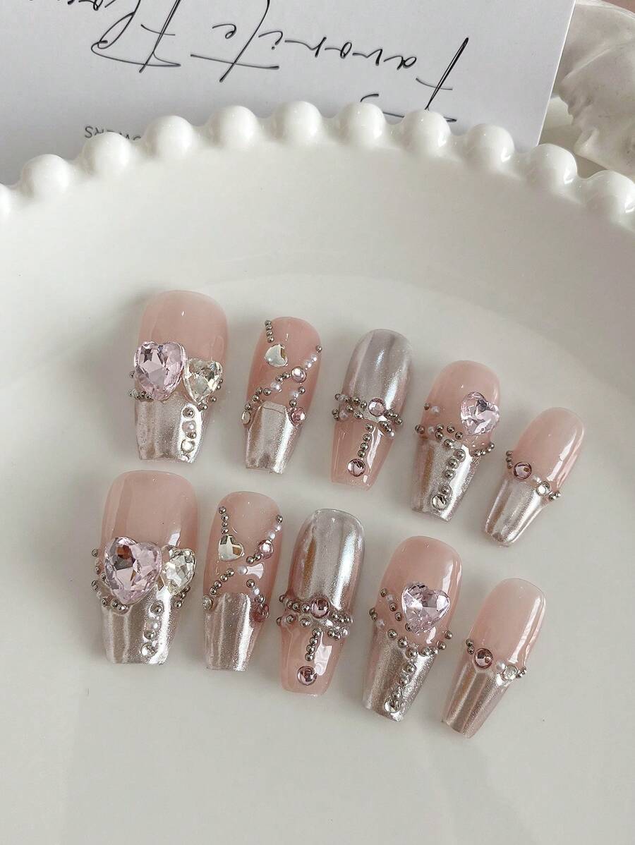 10 pièces de manchettes pour ongles de forme cercueil longue, faites à la main, délicates, avec de douces perles et strass en forme de cœur. Set de cache-ongles de style français avec chaîne de perles. Convient pour les mariées, les fêtes et l'usage quotidien. Livré avec 1 pièce de gel à ongles et 1 pièce de repoussoir à ongles