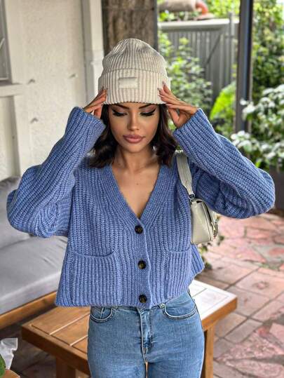 A KNIT CARDIGAN WITH BUTTON POCKET DETAILS