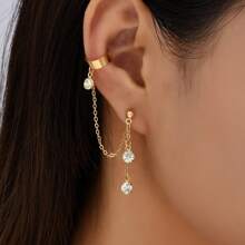 1 paire de boucles d'oreilles dorées style hip hop avec chaîne de strass à gland clip sur l'oreille