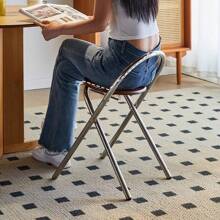 Une chaise de dossier pliable en acier inoxydable et rotin, simple et de luxe léger pour petit appartement. Tabouret de salle à manger pratique