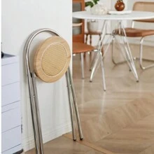 Une chaise de dossier pliable en acier inoxydable et rotin, simple et de luxe léger pour petit appartement. Tabouret de salle à manger pratique