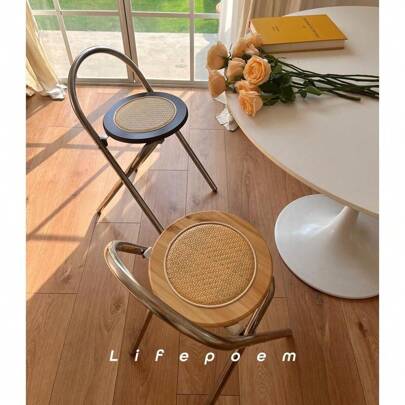 Una silla con respaldo plegable de acero inoxidable y ratán, sencilla y de lujo ligero, conveniente para acomodar en pequeños apartamentos como taburete de comedor