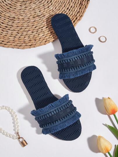 女款蓝色面料毛绒绒球流苏装饰波西米亚风平底凉鞋，度假风。绒球和流苏装饰的长度和数量随机，面料材质和蓝色复古图案随机。