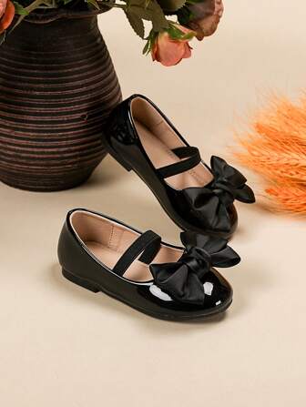 小女孩可爱黑色漆皮平底鞋，带蝴蝶结装饰