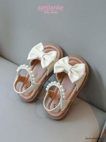 Nuevas sandalias planas para niños, sandalias de princesa coreana para bebés con diseño de lazo de perlas en la suela suave y antideslizante, uso casual y cómodo para el verano