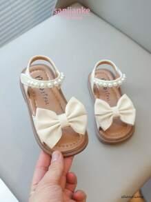 Nuevas sandalias planas para niños, sandalias de princesa coreana para bebés con diseño de lazo de perlas en la suela suave y antideslizante, uso casual y cómodo para el verano
