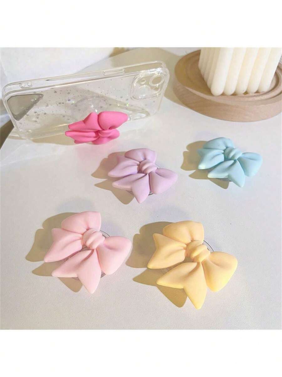 采用 ABS 材质的马卡龙蝴蝶结手机支架，防水，适用于智能手机的多功能支架，彩色哑光桌面支架