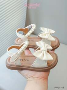 Nuevas sandalias planas para niños, sandalias de princesa coreana para bebés con diseño de lazo de perlas en la suela suave y antideslizante, uso casual y cómodo para el verano
