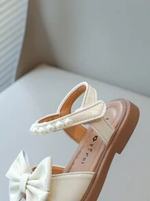 Nuevas sandalias planas para niños, sandalias de princesa coreana para bebés con diseño de lazo de perlas en la suela suave y antideslizante, uso casual y cómodo para el verano