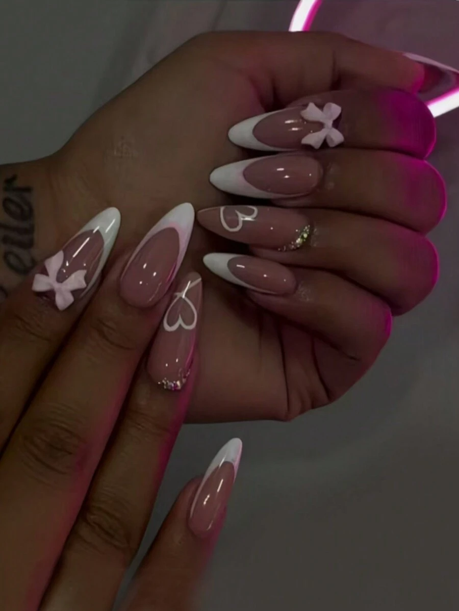 Exprimez votre amour avec 24 faux ongles en forme d'amande pour la Saint-Valentin. Style français blanc élégant simple avec cristaux 3D, nœuds roses. Faux ongles roses en forme de cœur mignon pour la Saint-Valentin et la Fête des Mères. Kit complet de faux ongles pour femmes et filles, comprend un salon de manucure avec 1 pièce de gel jelly et 1 lime. Expédition aléatoire du gel jelly.