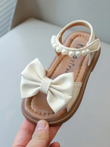 Nuevas sandalias planas para niños, sandalias de princesa coreana para bebés con diseño de lazo de perlas en la suela suave y antideslizante, uso casual y cómodo para el verano