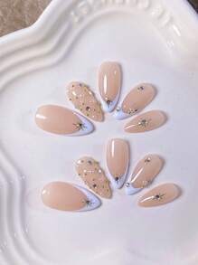 10 Mẫu Móng Tay Giả Hình Hạnh Nhân Thủ Công: Đầu móng kiểu Pháp màu trắng với họa tiết ngôi sao, ngọc trai, hạt thép và kim cương phủ kín – Phù hợp cho môi trường công sở, dễ thương, tinh tế, tối giản, thời trang và cao cấp. - trắng - Xem 5