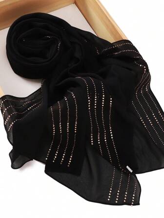 一件镶满水晶的黑色雪纺头巾，适合搭配连衣裙穿着，可作罩袍或头巾。