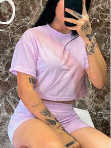 Este conjunto de dama es perfecto para los días cálidos, compuesto por una blusa de manga corta y un short corto, ideales para un look fresco y cómodo. La blusa presenta un diseño sencillo con cuello redondo, proporcionando un toque clásico y elegte, mientras que el short corto liso, confeccionado en tela CANALE, ofrece una textura resistente y cómoda.  La tela CANALE, conocida por su durabilidad y suavidad, asegura un ajuste cómodo durante todo el d, mientras que su diseño liso lo hace fácil de combinar con accesorios y calzado, adaptándose a diferentes estilos. Es un conjunto versátil, perfecto para paseos, reuniones informales o para disfrutar del verano con estilo. - Lila Púrpura - Ver 3