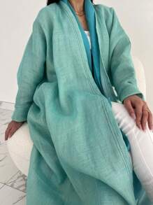 这款时尚简约的女士纯色长袍，搭配时尚优雅的开襟羊毛长袍，充分展现了中东风情，适合日常生活和度假穿着，是一款端庄的卡夫坦长袍。