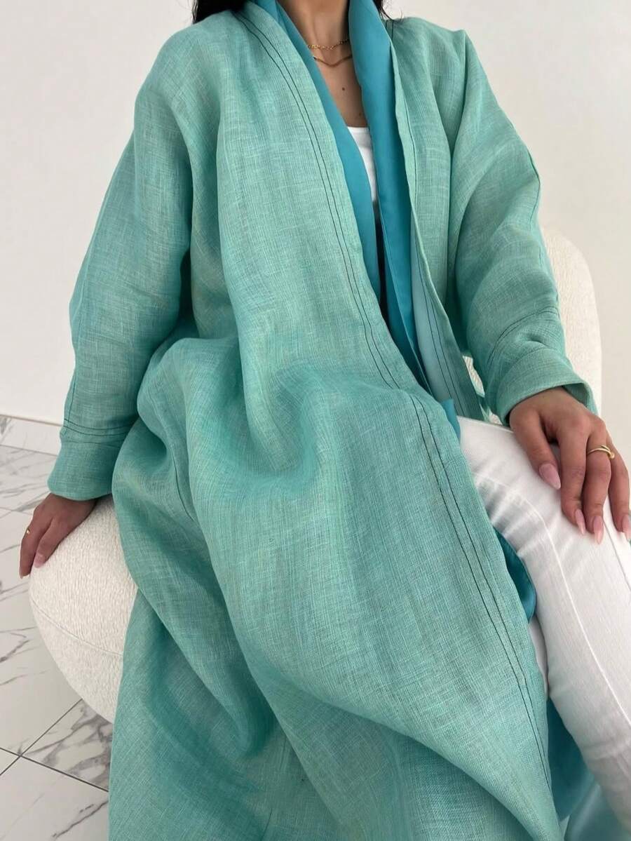 这款时尚简约的女士纯色长袍，搭配时尚优雅的开襟羊毛长袍，充分展现了中东风情，适合日常生活和度假穿着，是一款端庄的卡夫坦长袍。