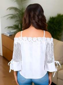Blusa holgada con hombros descubiertos, con empalmado de encaje y malla con diseño floral y cierre delantero de lazo