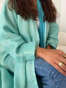 这款时尚简约的女士纯色长袍，搭配时尚优雅的开襟羊毛长袍，充分展现了中东风情，适合日常生活和度假穿着，是一款端庄的卡夫坦长袍。