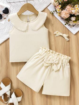 少女百褶领无袖上衣搭配高腰蝴蝶结短裤套装，柔软亲肤，清新简约，适合日常穿着或亲子拍照，营造优雅俏皮风格，春夏