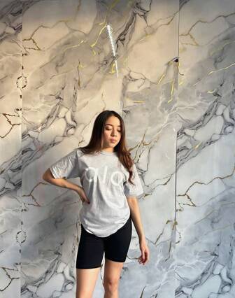 Conjunto 2 piezas camiseta oversize con mangas caídas unicolor con estampado en parte delantera y short tipo biker tela licra ajustados para dama