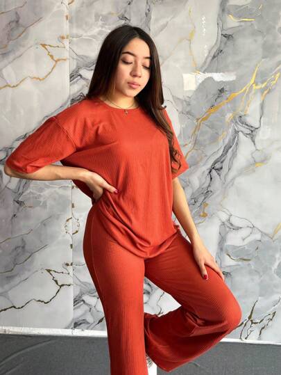 Conjunto informal rojo de dos piezas para mujer, camiseta de media manga con cuello redondo y pantalón largo con tejido ligeramente elástico.
