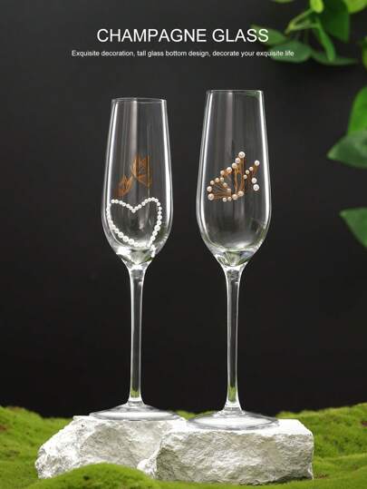 两只水晶香槟杯，饰以蝴蝶和珍珠，手工打造心形珍珠蝴蝶图案，玻璃材质，是居家、餐厅、派对、婚礼、订婚、情人节、母亲节、周年纪念日等场合的理想礼物。