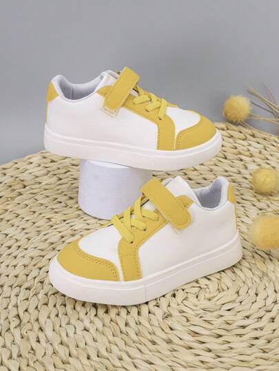 Un par de zapatos blancos de moda para niños y niñas con decoración de bloques de color amarillo, ligeros, impermeables, planos, tipo tenis, cómodos y antideslizantes, adecuados para actividades al aire libre durante todo el año