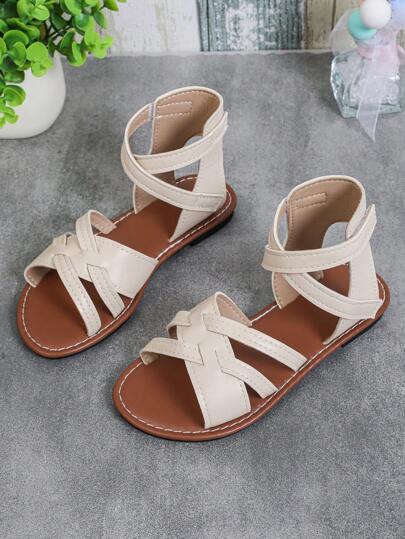 1 par de sandalias planas para niñas de talla grande, color beige sólido, de piel de PU, con correa cruzada, cierre, punta redonda, punta abierta, sandalias romanas de moda y lindas de plataforma alta, adecuadas para niños y niñas de 3 a 16 años, para uso casual, vacaciones, viajes, primavera/verano 2025