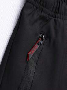 Pantalonii sport slim-fit pentru bărbați sunt confecționați dintr-un material ușor și elastic din amestec de poliester și sunt prevăzuți cu buzunare cu fermoar. Sunt potriviți pentru alergare și ținute casual, oferind confort și având o gamă largă de aplicații.