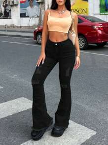 Jeans a zampa di donna con bordi sfilacciati e dettagli strappati