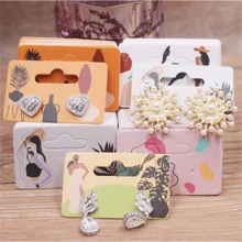 Paquete de 100 piezas de pendientes de gota con diseño de chica guiñando o chica tomando una foto, de 5,5 x 3,5 cm, con tarjeta de embalaje con diseño de patrones
