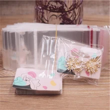 Paquete de 100 piezas de pendientes de gota con diseño de chica guiñando o chica tomando una foto, de 5,5 x 3,5 cm, con tarjeta de embalaje con diseño de patrones