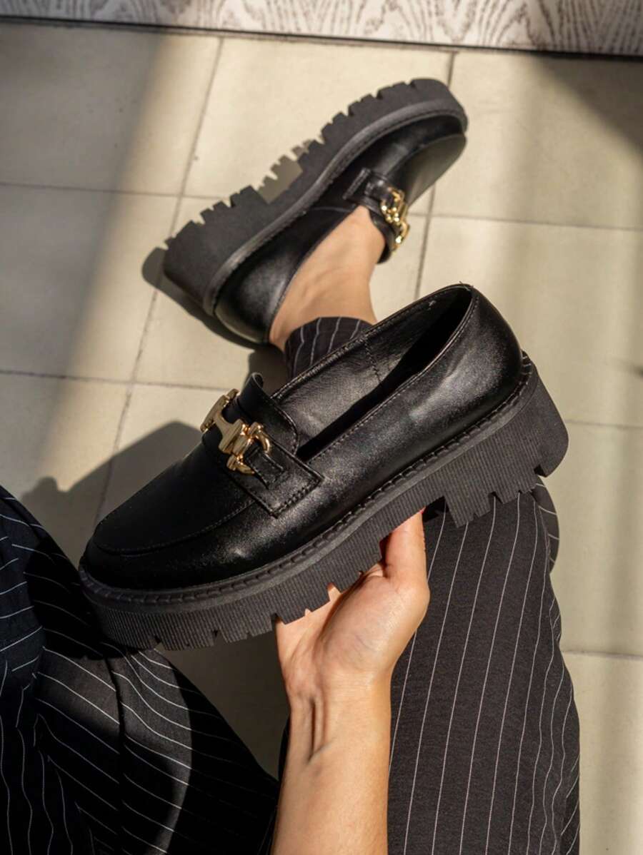 Mocasines negros para mujer con plataforma gruesa, suela gruesa antideslizante, diseño tipo mocasines con detalle de eslabón dorado, ideales para oficina, escuela, eventos formales y uso diario. Calzado cómodo y versátil, perfecto para outfits elegantes, casuales y urbanos. Zapatos sin agujetas con suela dentada y tacón bajo para mayor estabilidad. Mocasines modernos de estilo minimalista para combinar con faldas, pantalones de vestir, jeans o vestidos. Calzado para otoño-invierno y primavera-verano. Zapatos tipo colegiales para mujer con acabado brillante. Zapatos planos con plataforma para looks favorecedores y contemporáneos. Calzado chunky para mujer. Mocasines negros. - Negro - Ver 1
