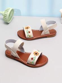 可爱又迷人的凉鞋！纯白色鞋面搭配暖棕色鞋底，简约又清新。双带设计紧贴宝宝脚部，穿脱方便。鞋面上有精致的花朵刺绣，色彩鲜艳，展现俏皮可爱的细节。鞋底柔软，行走舒适，是宝宝日常玩耍、外出和度假的时尚选择。