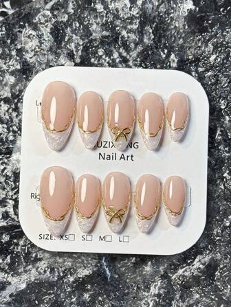 10片手工制作的法式短款美甲贴片。这款美甲套装包含白色、粉色、金色、蓝色和黄色五种颜色，风格可爱迷人。每片美甲都饰有手绘藤蔓图案，沿着金属质感的法式边缘蜿蜒而上，并点缀着金色和钻石蝴蝶结饰品。