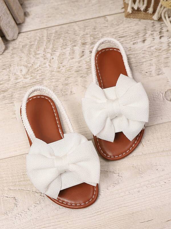 1 paire de sandales plates de grandes tailles pour bébé/tout-petit fille, blanc. Sandales d'été de style gladiateur à la mode avec décoration de nœud en maille de couleur unie, bride élastique au dos et semelle antidérapante légère. Convient pour les filles de 3 à 15 ans, pour le quotidien, les fêtes et les voyages.