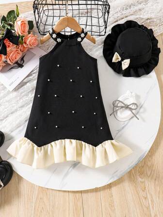 这款优雅的法式小黑裙适合年轻女孩，采用精致的珍珠装饰和荷叶边下摆，散发出精致而精致的外观。还配有一顶相配的黑色贝雷帽，增添了复古气息。这款套装非常适合生日派对、正式活动或拍照，是小公主的理想选择！