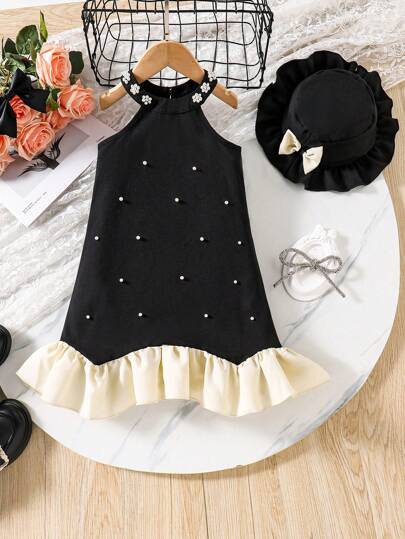 这款优雅的法式小黑裙适合年轻女孩，采用精致的珍珠装饰和荷叶边下摆，散发出精致而精致的外观。还配有一顶相配的黑色贝雷帽，增添了复古气息。这款套装非常适合生日派对、正式活动或拍照，是小公主的理想选择！