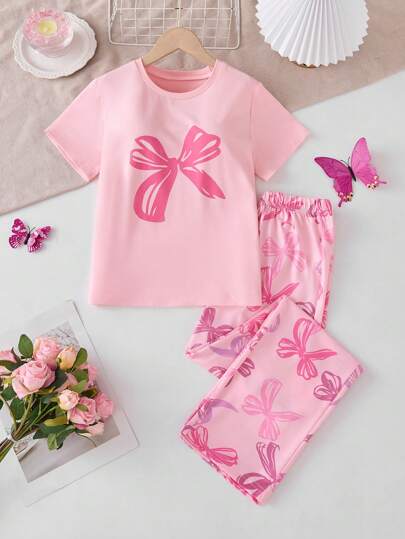 两件套女童休闲套装，包括一件粉色蝴蝶结印花圆领短袖上衣和一条彩色蝴蝶结印花长裤，公主风，适合春夏度假、情人节和日常休闲穿着。
