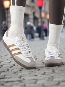 Adidas 阿迪达斯 Samba OG 男女通用运动鞋，皮革鞋面搭配绒面革饰边，舒适轻便的低帮系带休闲鞋，适合日常穿着和户外活动。 - 白/金 - 查看 4