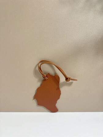 1件纯色PU材质，时尚简约，趣味十足的沙特阿拉伯地图挂件。可作汽车钥匙扣、车挂件、背包、单肩包、斜挎包、手提包、托特包、吊坠、行李配件等使用，适合情侣、学生、男士、女士、学校、工作、通勤、日常约会、假期、旅行和商务出行。也适合送给男孩、情人节、节日、女朋友、母亲等作为小礼物。