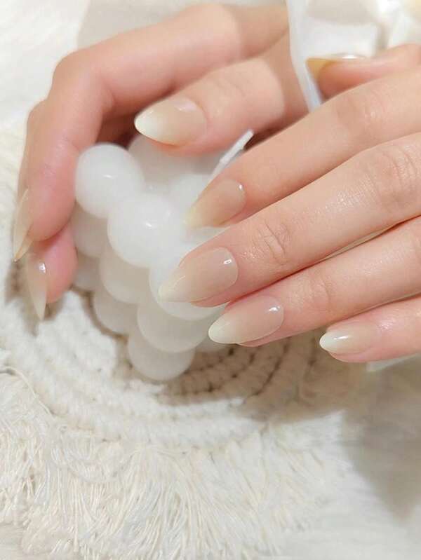 Set de 24 uñas postizas de forma de almendra corta con degradado de colores nude y blanco lechoso. Incluye 1 bloque de lijado de uñas y 1 gel de gelatina